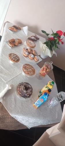 a table with a bunch of donuts on it at AFFITTACAMERE DAL TRAMONTO ALL'ALBA in Montesano Scalo
