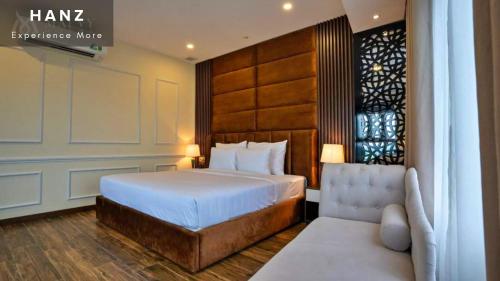 a bedroom with a bed and a chair in it at HANZ Premium Mai Vy Hotel in Tây Ninh