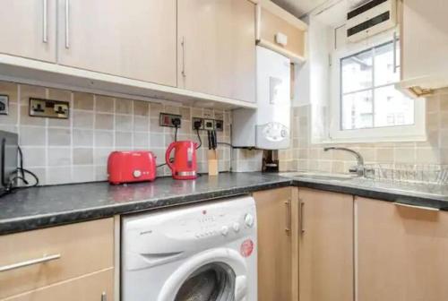 a kitchen with a washing machine in a kitchen at APlaceToStay Central London Apartment, Zone 1 BOND in London