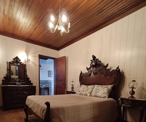 um quarto com uma cama grande e um lustre em Casa do Conde Praia da Barra em Gafanha da Nazaré