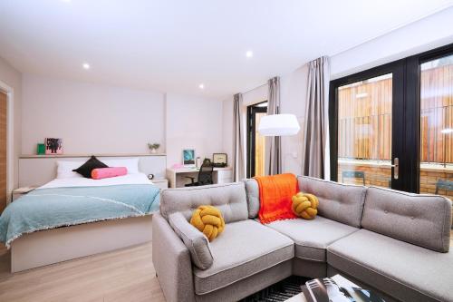 a bedroom with a couch and a bed at JOIVY at Vita Iona Street - Adults only in Edinburgh