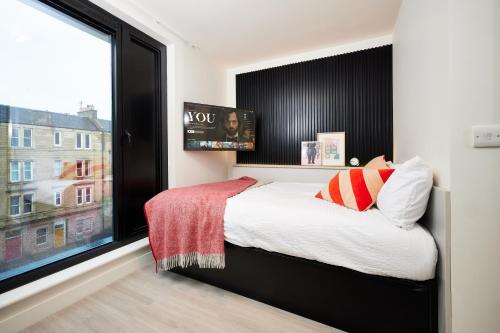 a bedroom with a bed and a large window at JOIVY at Vita Iona Street - Adults only in Edinburgh