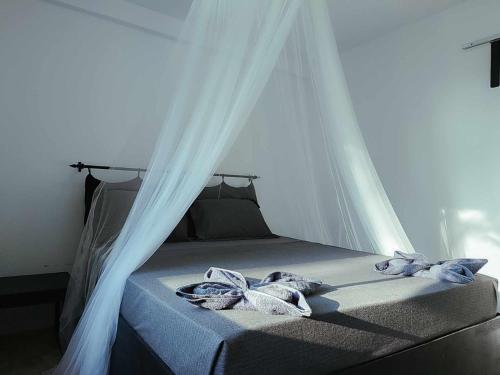 a bed with a canopy and two towels on it at Paradise Sunset Beach in Koh Rong Sanloem