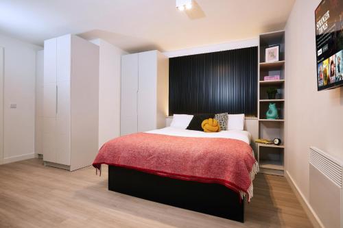 1 dormitorio con 1 cama grande con manta roja en ALTIDO Aparthotel at Vita Iona Street - Adults only en Edimburgo