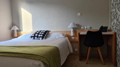 a bedroom with a bed and a desk with a phone at Sweet Home in Belley