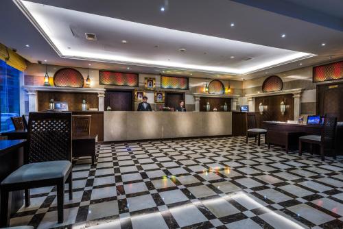 a restaurant with a bar with a man in the background at First Central Hotel Suites in Dubai