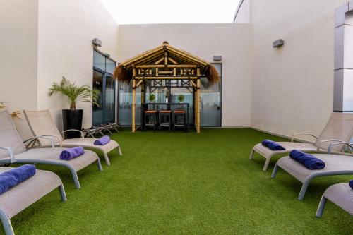 a room with chairs and a green carpet at First Central Hotel Suites in Dubai