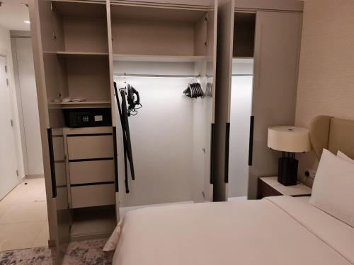 a bedroom with a white bed and a closet at Two Bedroom-The Address Beach Resort Fujairah in Sharm
