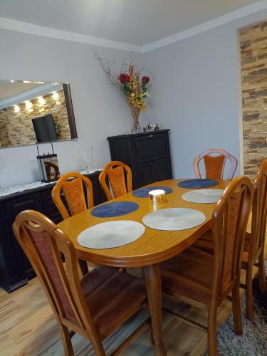 a dining room with a wooden table and chairs at DOM w JESIONACH Brajniki - działka 1 HEKTAR in Jedwabno