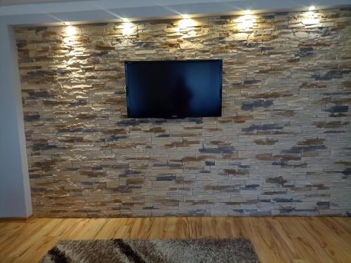 a flat screen tv on a stone wall at DOM w JESIONACH Brajniki - działka 1 HEKTAR in Jedwabno