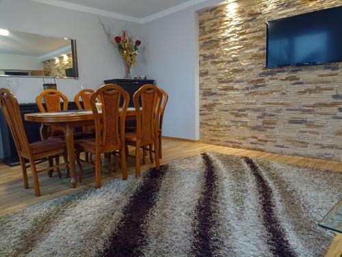 a dining room with a table and chairs and a brick wall at DOM w JESIONACH Brajniki - działka 1 HEKTAR in Jedwabno