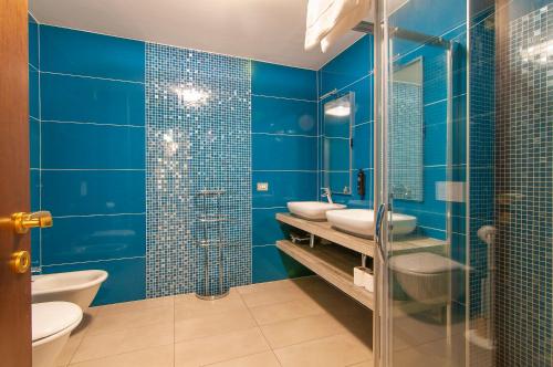ein blaues Badezimmer mit 2 Waschbecken und 2 WCs in der Unterkunft Dimore Verona 2 in Verona
