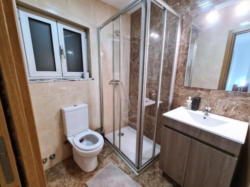 a bathroom with a shower and a toilet and a sink at MR House - Self Check-in in Coimbra