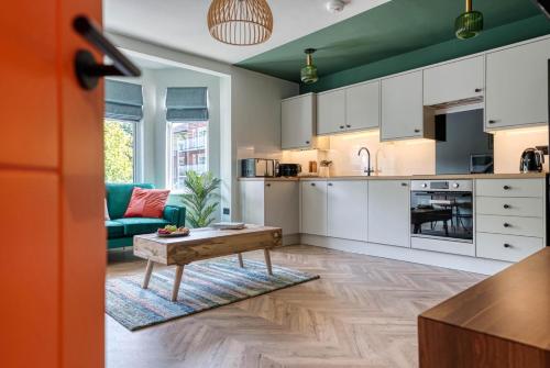a kitchen with white cabinets and a table in a room at First Floor - Stylish 3 Bedroom Apartment in Southampton