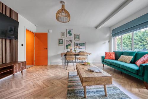 a living room with a green couch and a table at First Floor - Stylish 3 Bedroom Apartment in Southampton