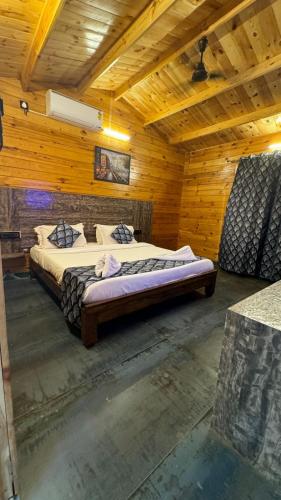 a bedroom with a bed in a wooden room at OZIBA BEACH RESORT in Arambol