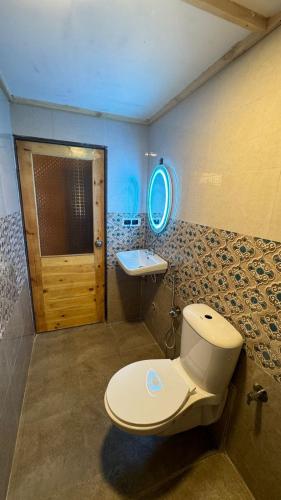 a bathroom with a toilet and a sink at OZIBA BEACH RESORT in Arambol