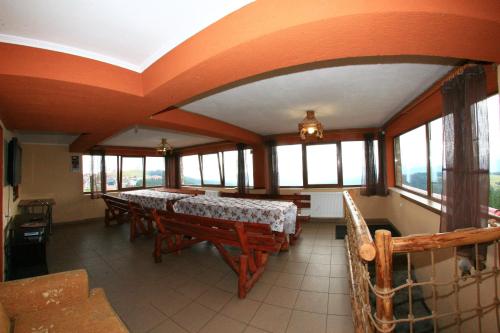a dining room with a table and some windows at Piatra Rancii in Ranca
