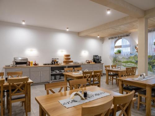a restaurant with wooden tables and chairs and a kitchen at Rezydencja Widokowa in Bukowina Tatrzańska