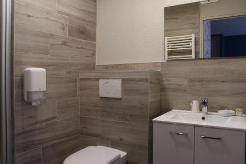 ベリニャにあるOyonnax Bellignat Appart Hotelのバスルーム(トイレ、洗面台、鏡付)