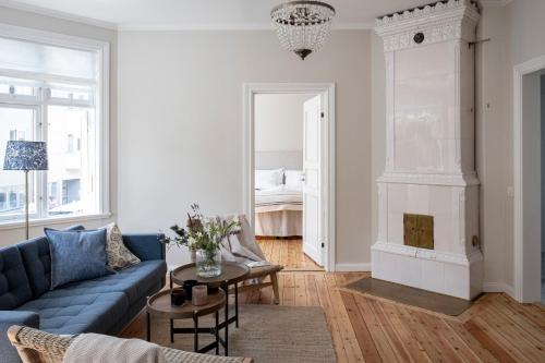 ein Wohnzimmer mit einem blauen Sofa und einem Kamin in der Unterkunft Blå Huset in Vaxholm