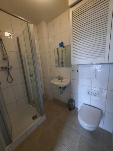 uma casa de banho com um chuveiro, um WC e um lavatório. em FEWO1-1 Zim Apart-4 Bett-Küche-Dusche WC-Parkplatz em Berlim