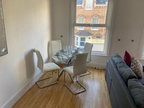 a living room with a table and chairs and a couch at OPP Exeter RRF&T - Cosy 1 bed with parking BIG SAVINGS booking 7 nights or more! in Exeter