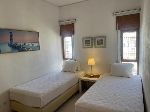 una habitación con dos camas y una mesa con lámpara en Armação de Pêra - Beach Apartment - Sea View- Walk to the Beach - Algarve, en Armação de Pêra