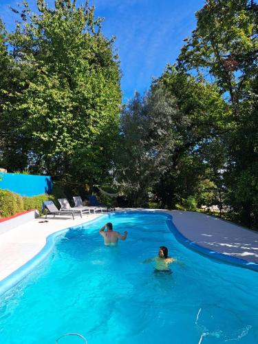 two people are swimming in a swimming pool at Quinta Abelha in Três Horas