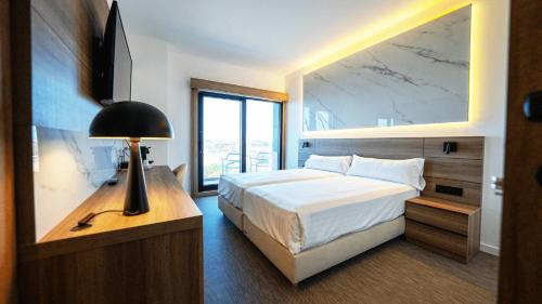 een slaapkamer met een groot bed en een groot raam bij Hotel Inffinit Sanxenxo in Sanxenxo
