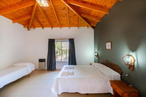 a bedroom with two beds and a large window at Cerro de los Duendes in Santa Rosa de Calamuchita