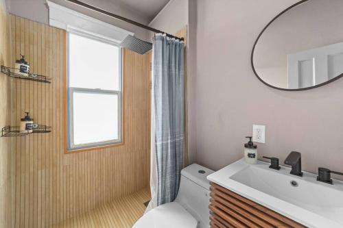 a bathroom with a toilet and a sink and a mirror at Pet Friendly 2BR in Little Italy in Cleveland