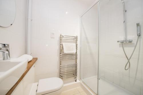uma casa de banho com um chuveiro, um WC e um lavatório. em Weasels Way at Tove Valley Cottages em Towcester