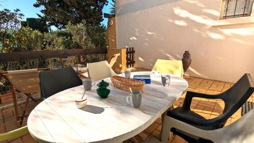 une table et des chaises en bois sur une terrasse dans l'établissement 5046 Tennis Village plus 1405, au Cap d'Agde