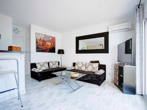 un salon avec un canapé et une télévision dans l'établissement 5046 Tennis Village plus 1405, au Cap d'Agde