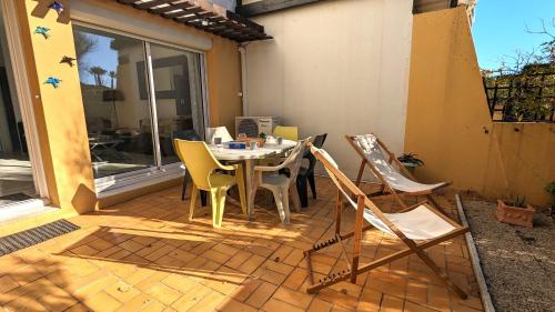 un patio avec une table et des chaises sur un patio dans l'établissement 5046 Tennis Village plus 1405, au Cap d'Agde