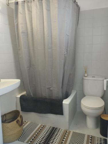 ein Bad mit einem WC und einem Duschvorhang in der Unterkunft Casa Bahía in Arbúcies