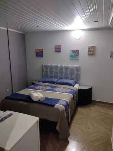 a bedroom with a bed with blue sheets and a headboard at LVL Hospedaje Ejecutivo in Ciudad del Este