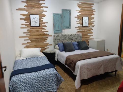 a bedroom with two beds and two pictures on the wall at LVL Hospedaje Ejecutivo in Ciudad del Este