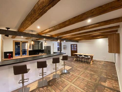 une cuisine avec un bar et une table avec des chaises dans l'établissement Les 7 Prunes - Demeure Alsacienne d'Exception, à Zellwiller