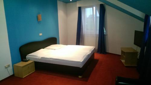 a bedroom with a bed in a blue room at Casino & Pension Admiral Dolní Dvořiště in Dolní Dvořiště