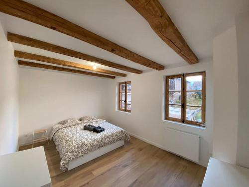 um quarto com uma cama num quarto com tectos em madeira em Le Grain Noble - Demeure Alsacienne de Caractère em Zellwiller