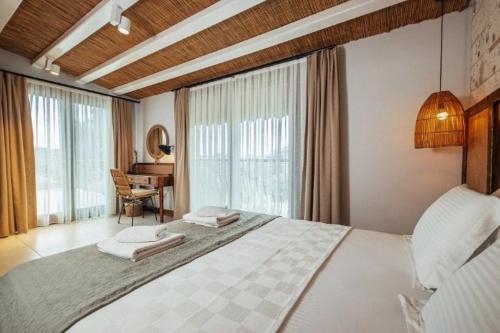 una camera con un grande letto in una stanza con una scrivania di N Hotels Çeşme a Dalyanköy