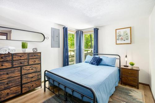 1 dormitorio con 1 cama, vestidor y ventana en Wooded family-size Chalet with Fire pit & Hot tub!, en Hedgesville