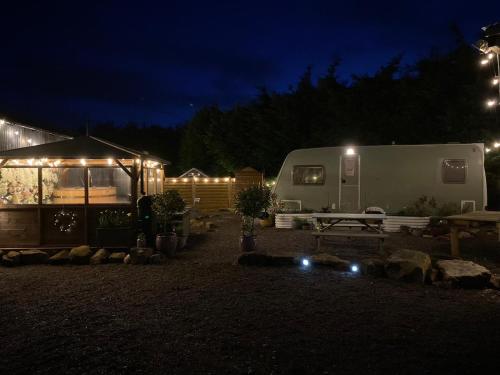 a trailer and a tent in a yard at night at Top Pen Y Parc Farm Glamping in Holywell