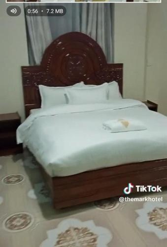 a bed with a wooden headboard in a room at THE MARK HOTEL in Nairobi