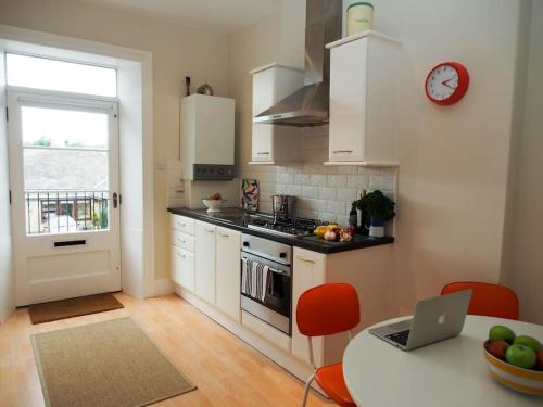 a kitchen with a table and a laptop on the counter at Stunning apartment in the centre of Corbridge in Corbridge
