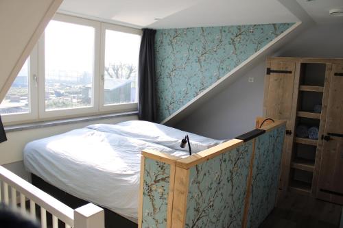 a small bedroom with a bed and a staircase at Huis over de dijk in De Kwakel