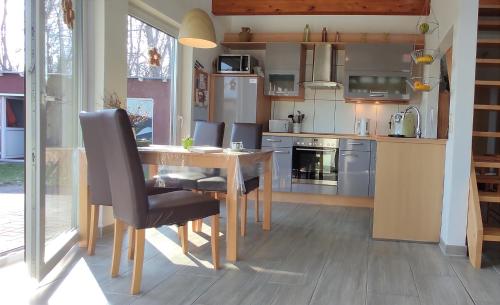 a kitchen with a wooden table and chairs in a room at Nah´n Kliff 76 in Timmendorf