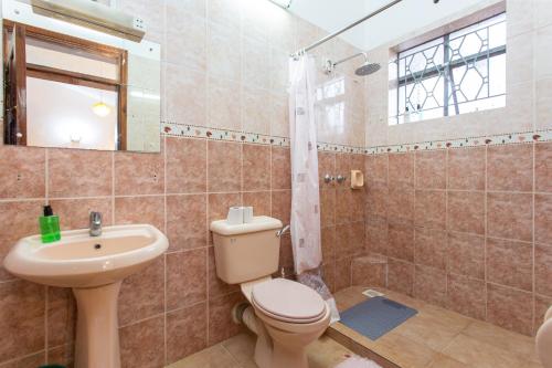 a bathroom with a toilet and a sink at Bonsai Villa in Nairobi